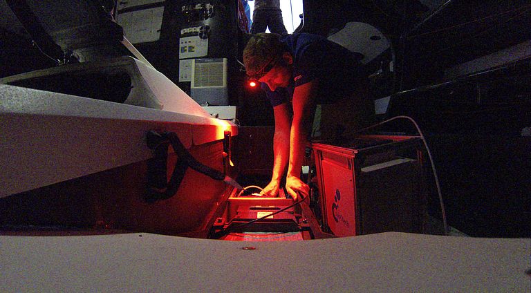 Sören Gutekunst installiert einen Sensor im Rumpf der Yacht AkzoNobel. Foto: Sören Gutekunst/Ozean der Zukunft