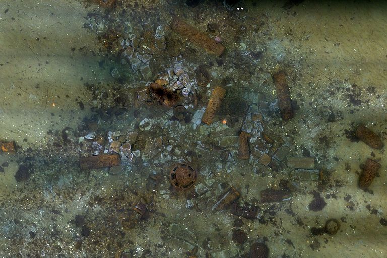 Ein zusammengesetztes Foto zeigt etliche Munitionskisten auf dem Meeresboden