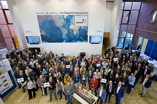 Gruppenbild in dem Foyer eines Forschungszentrum, rund 150 Menschen 