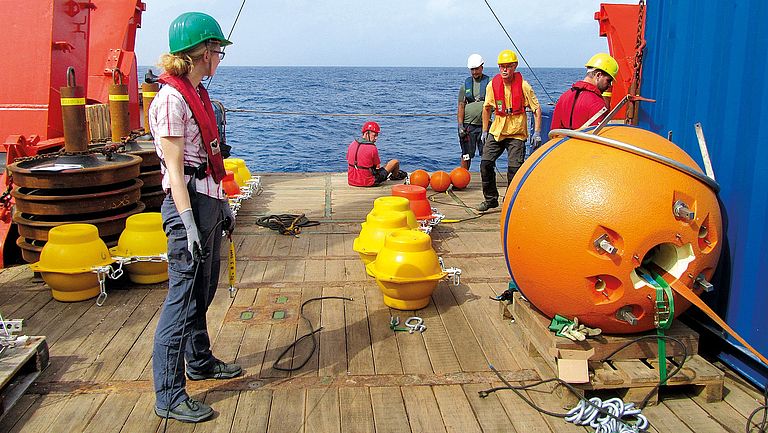 Preparation: On the deck of a research vessel, buoyancy bodies and sensors are prepared for mooring.