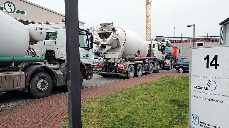 Concrete mixer trucks wait to be used for shell construction
