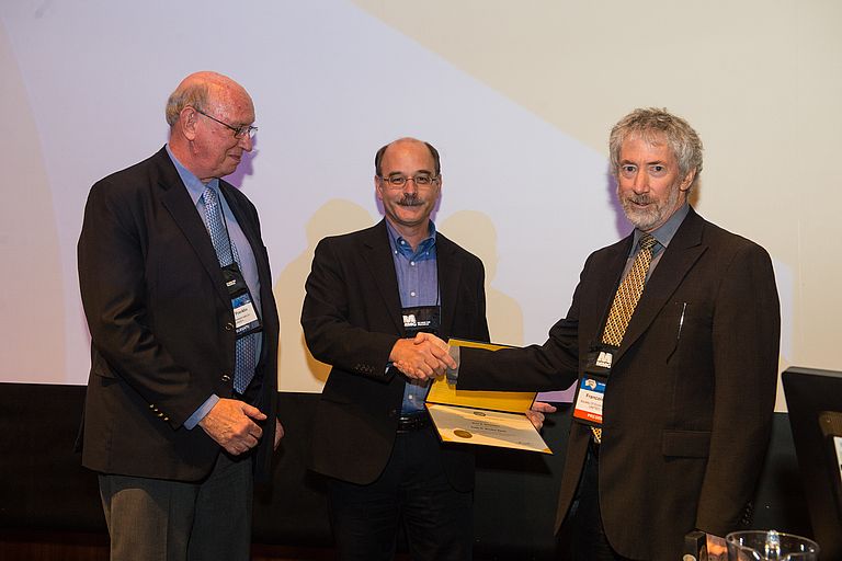 Francois Robert, Präsident der SEG (re.) und James M. Franklin gratulieren Mark Hannington (Mitte) zum Ralph W. Marsden Award. Foto: SEG