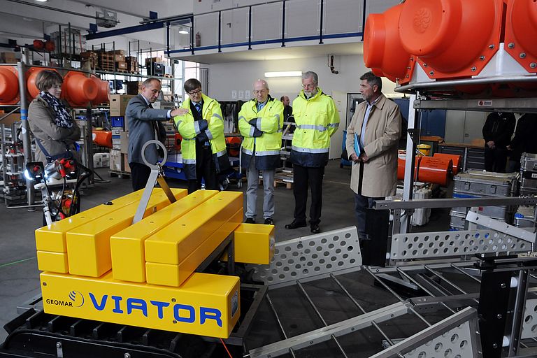 Dr. Peter Linke, Wissenschaftlicher Leiter des Technik- und Logistikzentrums (2.v.l.) erläutert Prof. Dr. Otmar Wiestler (3.v.l.) den Tiefseecrawler Viator. Foto: J. Steffen, GEOMAR.