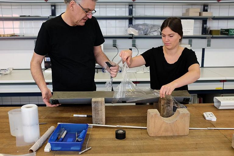 Im Labor untersuchen ein Wissenschaftler und eine Wissenschaftlerin die halbierten Bohrkerne weiter. Foto: Jan Steffen, GEOMAR.
