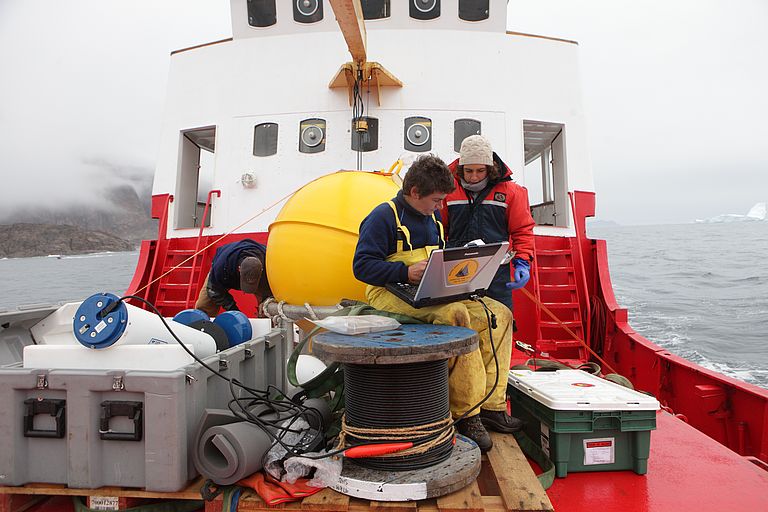 Marilena Oltmanns, Erstautorin der aktuellen Studie (stehend), zusammen mit Co-Autorin Fiammetta Straneo während einer Expediton vor der grönländischen Küste, bei die Forscherinnen den Austausch zwischen dem Schmelzwasser vom Gletscher und dem Ozean untersuchen. Foto: Dave Sutherland.