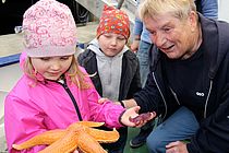 Ob der Seestern wohl piekt? Heidi Gonschior (links) zeigt den Nachwuchsforschern Meeresbewohner der Ostsee. Foto: A. Villwock, GEOMAR.