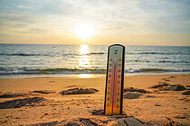 A thermometer in the sand at the beach showing 40 degrees Celsius