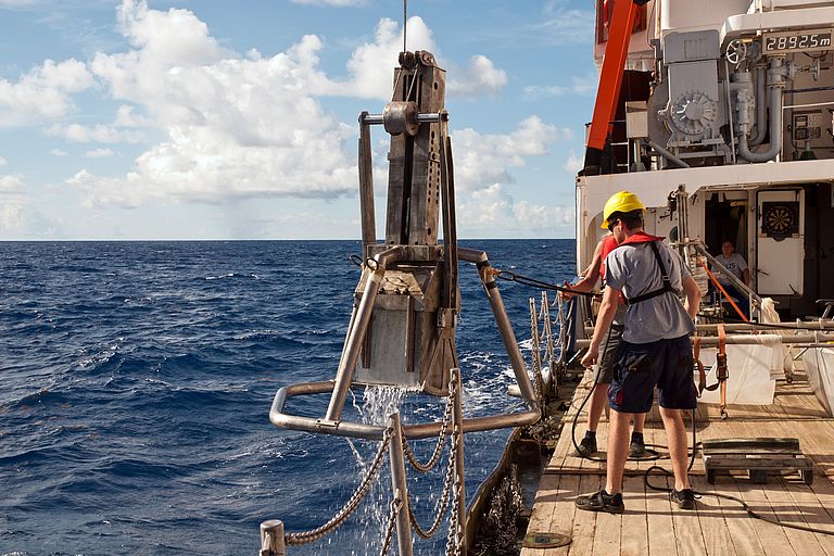 Ein Kastengreifer hängt neben der Bordwand des Forschungsschiffs POSEIDON. Foto: Mark Lenz/GEOMAR