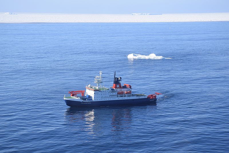 Luftaufnahme des Forschungsschiffs Polarstern mit Eisbergen im Hintergrund